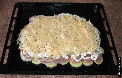 На мясо выкладываем подготовленный лук, поверх которого майонез и слой сыра